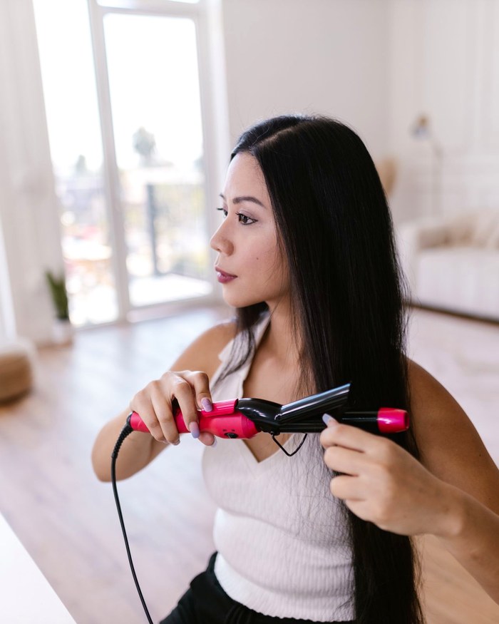 Long hair being smoothed with a flat iron