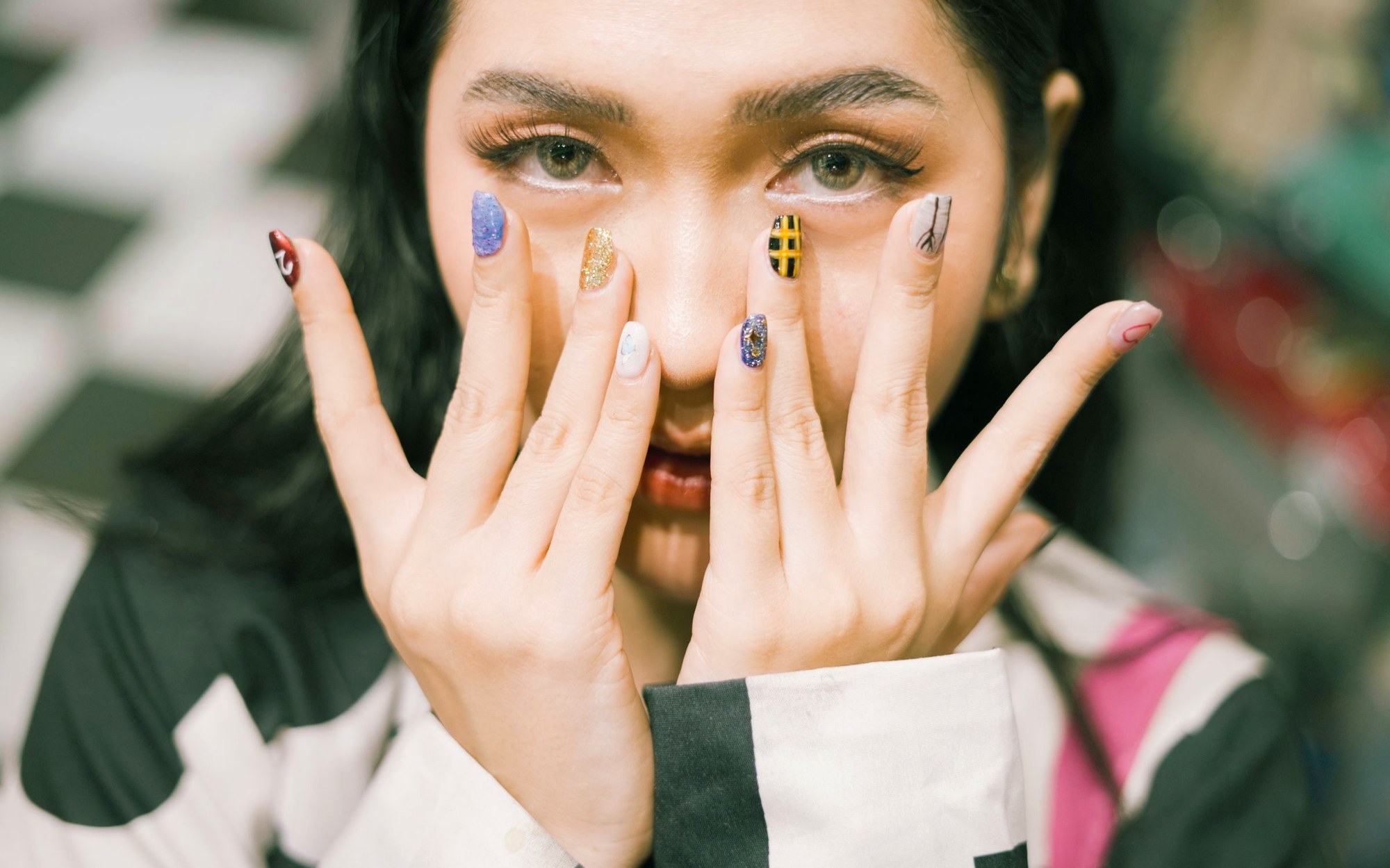 Hands showing bright, colourful nail art