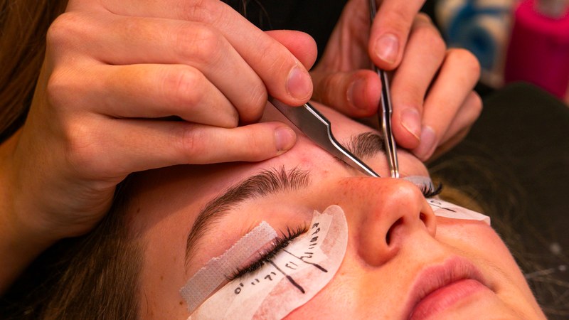 A lash artist mapping a set before applying extensions