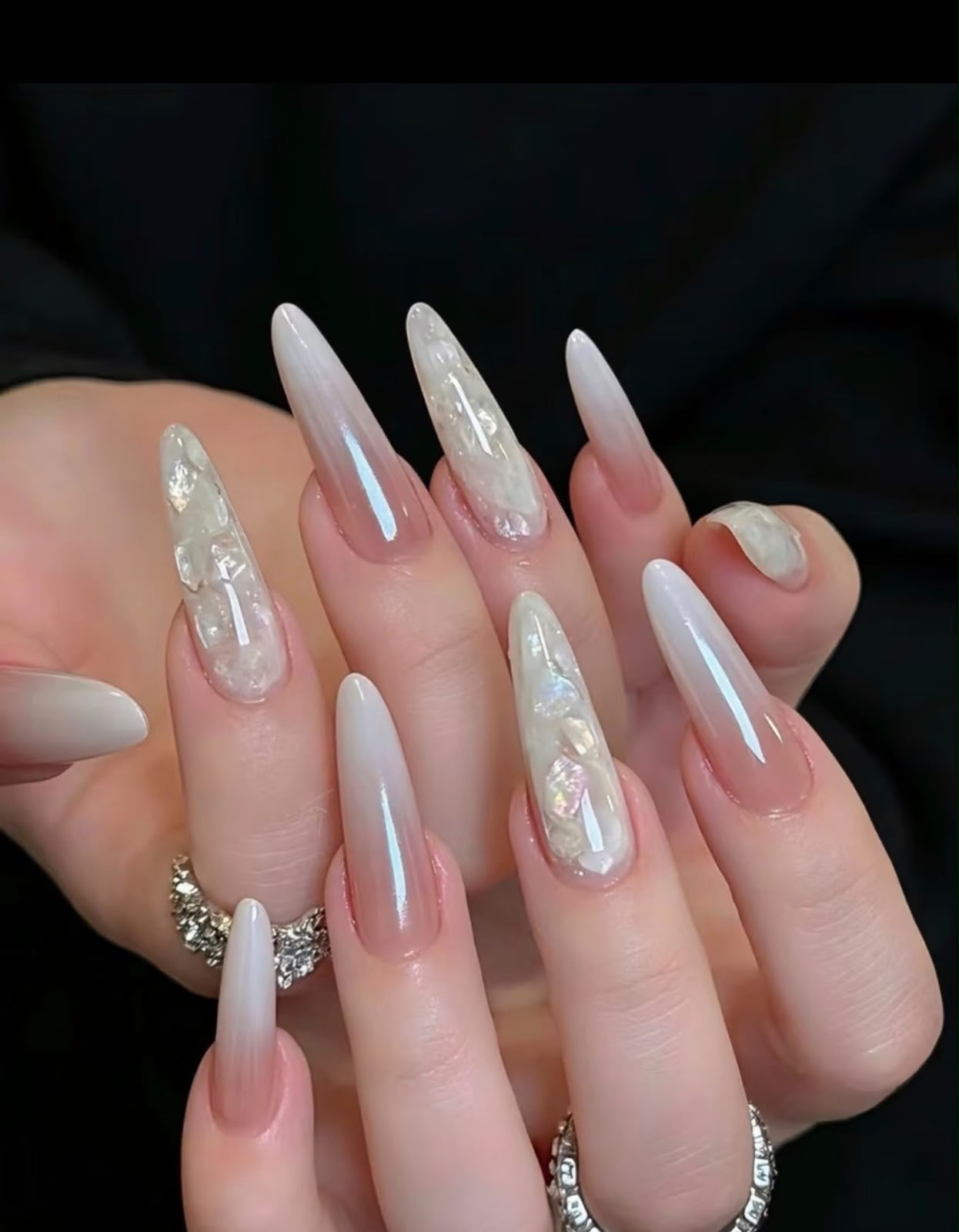 Long almond nails in a milky white ombre with iridescent shell-flake accents
