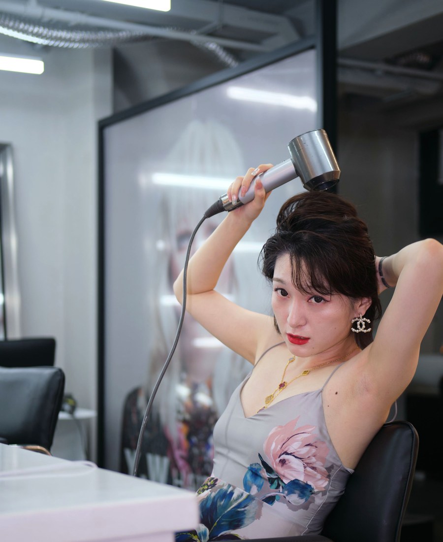 A client finishing her own blow-dry at the styling station