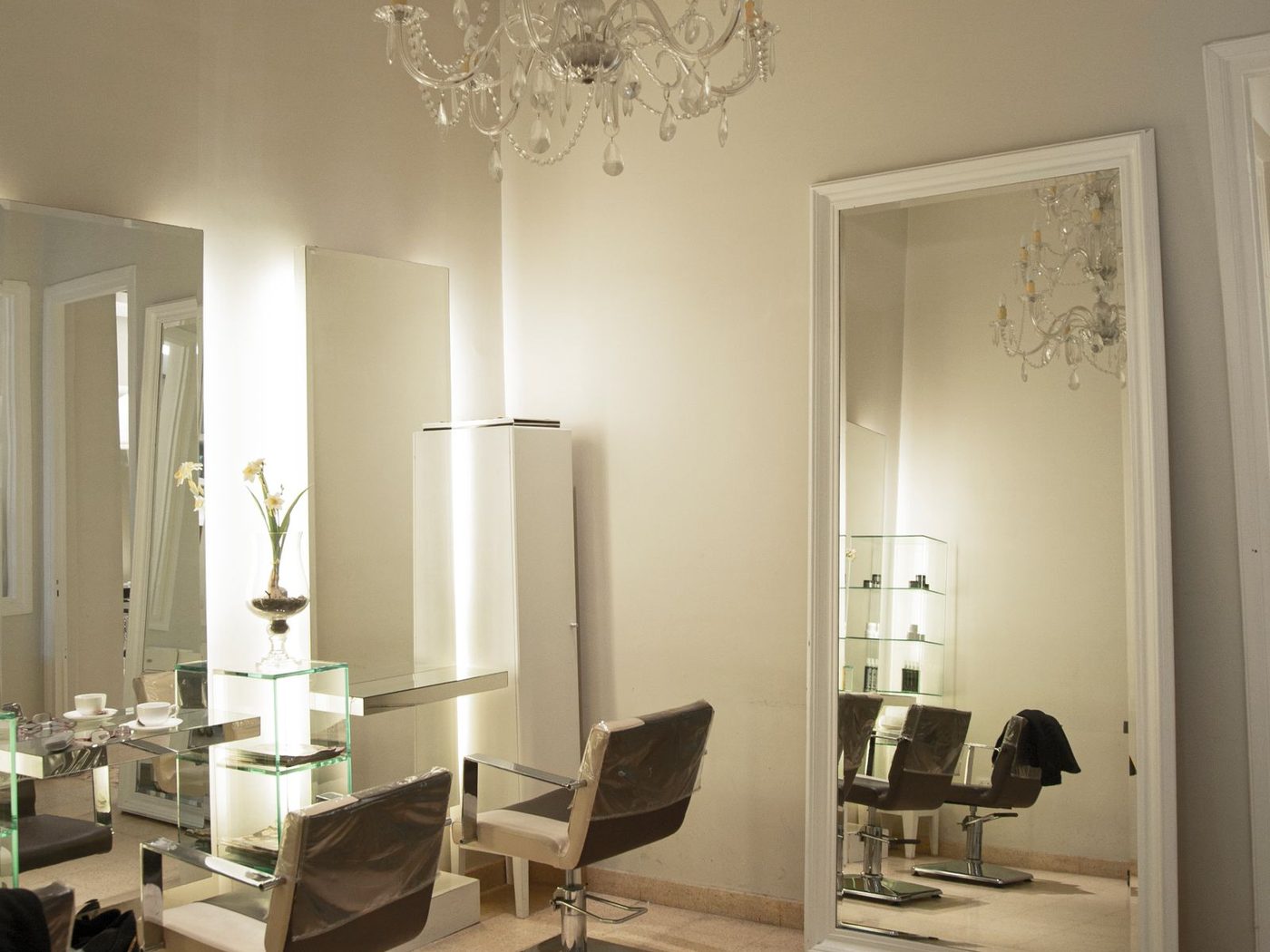 Full-length mirrors and styling chairs in the warm-lit corner of the studio