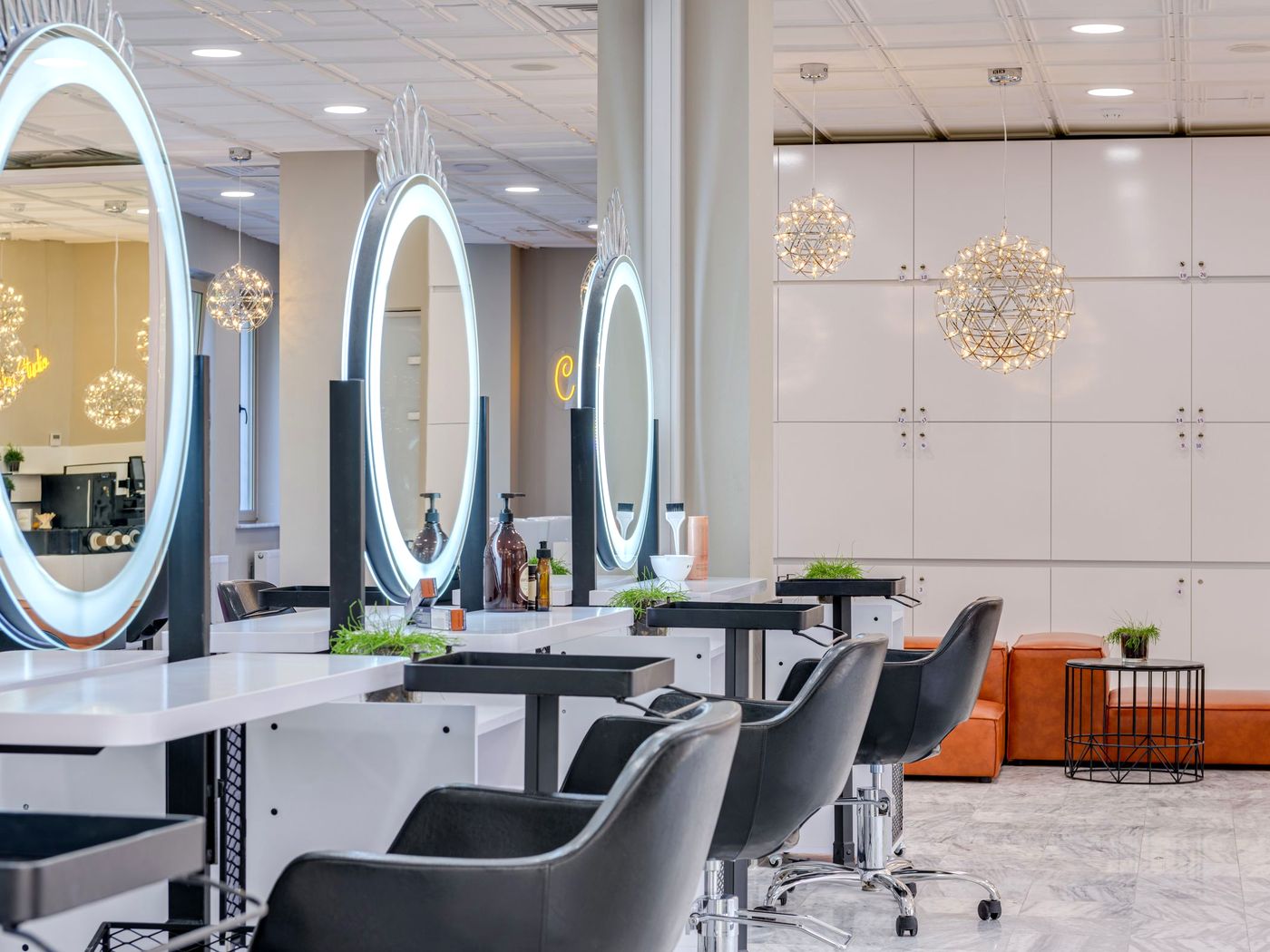 Bright styling stations with lit mirrors along the studio floor